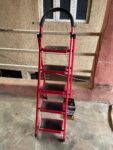  Red, foldable, 5-step hand-grip ladder, likely made of aluminum. 