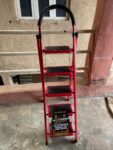  Red, foldable, 5-step hand-grip ladder, likely made of aluminum. 
