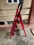  Red, foldable, 5-step hand-grip ladder, likely made of aluminum. 
